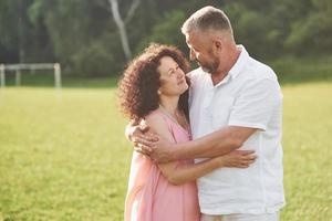 A loving, handsome senior couple outdoors in the park, many years together photo