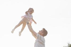 Father and daughter are playing together outdoors photo