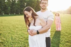 Two families of different generations embrace. Young husband and wife as well as their old parents who still love each other photo