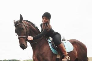 Young pretty girl - riding a horse, equestrian sport in spring time photo