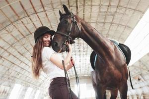 una niña feliz se comunica con su caballo favorito. la niña ama a los animales y a montar a caballo foto