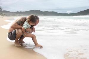 niño descubriendo el mar con su padre foto