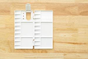 White watercolor palette. Empty watercolor tray isolated on wood background. photo