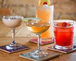 different colorful alcohol and non-alcohol cocktails in the glasses on the table photo