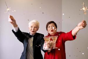 Two beautiful stylish mature senior women celebrating new year. Fun, party, style, celebration concept photo