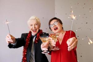 Two beautiful stylish mature senior women celebrating new year. Fun, party, style, celebration concept photo