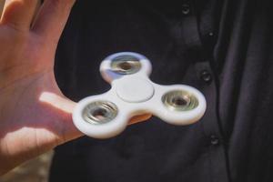 Young girl play with fidget spinner photo