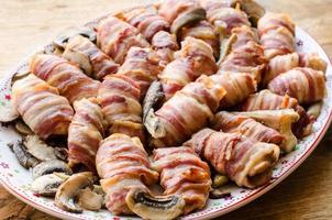 Wrapped baked bacon with button mushrooms photo