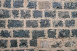 Texture of black basalt brick wall photo