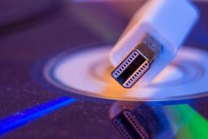 Closeup of white Mini Displayport cable with it's reflection on blank disc photo