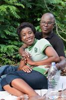 portrait of happy loving couple sitting in the forest. photo