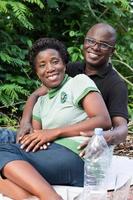 portrait of happy loving couple sitting in the forest. photo
