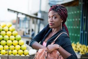 mano de mujer joven en la bolsa, mirando a la cámara foto