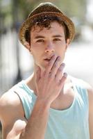 Handsome man wearing sun hat in urban background photo