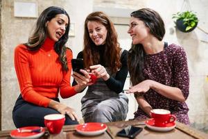 grupo de tres amigos felices tomando café en un bar cafetería. foto