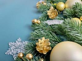 Christmas decorations, pine tree leaves, golden balls, snowflakes, golden berries on blue background photo