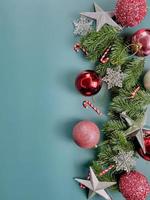 Christmas decorations, pine tree leaves, red balls, snowflakes, red berries on blue background photo