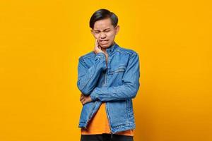 Portrait of Asian man touching mouth with painful expression photo