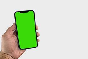 hombre sosteniendo smartphome con pantalla verde foto