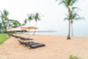 Abstract blur beach chair on beach with ocean sea for background - travel and vacation concept photo