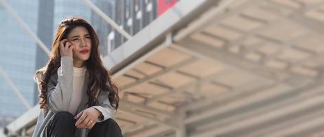 Lay off. Sacked. Fired business woman sitting on stairs of office building outside. photo