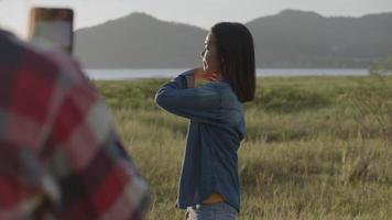 mujeres jóvenes tomando fotografías en el teléfono inteligente durante la puesta de sol video