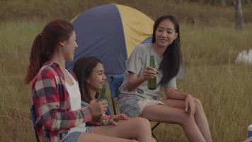 Asian woman sitting on a chair with friends and drinking beer video