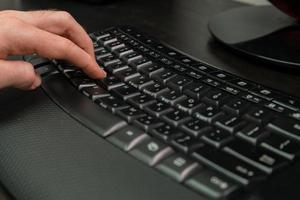 Hombre escribiendo en un teclado con letras en hebreo e inglés foto