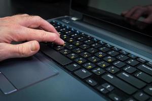 Man typing on a keyboard with letters in Hebrew and English photo