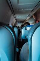 Interior of passenger airplane with people on seats photo