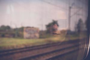 Mysterious woman face with black sunglasses reflected in the window of a traveling train photo