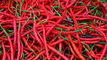 Chile rojo maduro maduro en la canasta para la venta en el mercado asiático de verduras