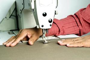 Hands work a sewing machine photo