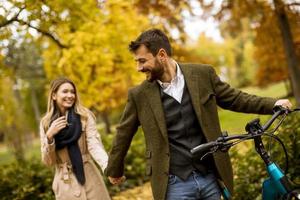pareja joven, en, el, otoño, parque, con, bicicleta eléctrica