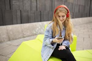 mujer joven escucha música desde el teléfono móvil foto