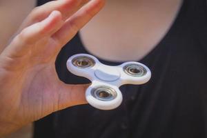 Young girl play with fidget spinner photo