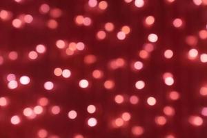 Defocused picture of bokeh for christmas and new year celebration on red background photo