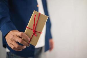 mano que sostiene la caja de regalo, caja de regalo de año nuevo, caja de regalo de Navidad, espacio de copia. Navidad, año nuevo, concepto de cumpleaños. foto