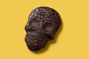 Calavera mexicana de chocolate sobre fondo amarillo foto