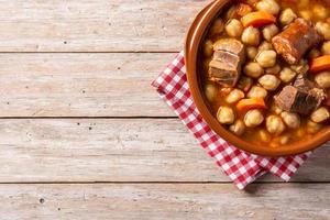 Traditional Spanish chickpeas with meat and carrot in bowl photo