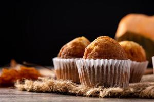 Pumpkin muffins on wooden table. Autumn food photo