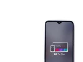 Pantalla de inicio de la aplicación LG TV Plus con logotipo en la pantalla de un teléfono inteligente móvil negro aislado sobre fondo blanco.