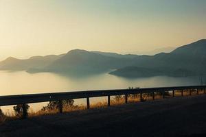 Beautiful view on sea and sunset over the distant mountains, film grain effect photo