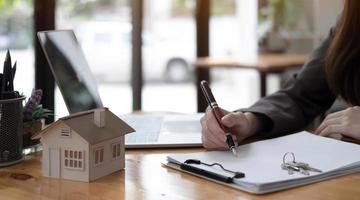 real estate realtor working in the office, reviewing rental contract on papers. Property consultant working in a modern office. photo