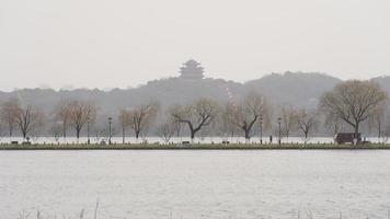 The beautiful Xihu landscape with the old arched bridge and temple tower in Hangzhou of the China in winter photo