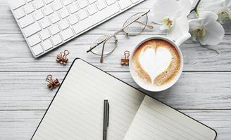 una taza de café con patrón de corazón en una mesa foto