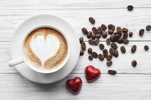 una taza de café con patrón de corazón en una mesa