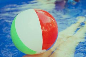 Colorful beach ball floating in pool photo