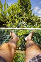 Man laying in hammock on a summer day photo