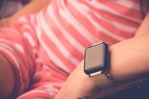 Smartwatch on sitting young woman hand photo
